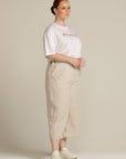 side view of a plus sized woman wearing beige linen culottes