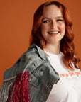 Woman in Denim jacket wearing fighting invisible battles enamel pin