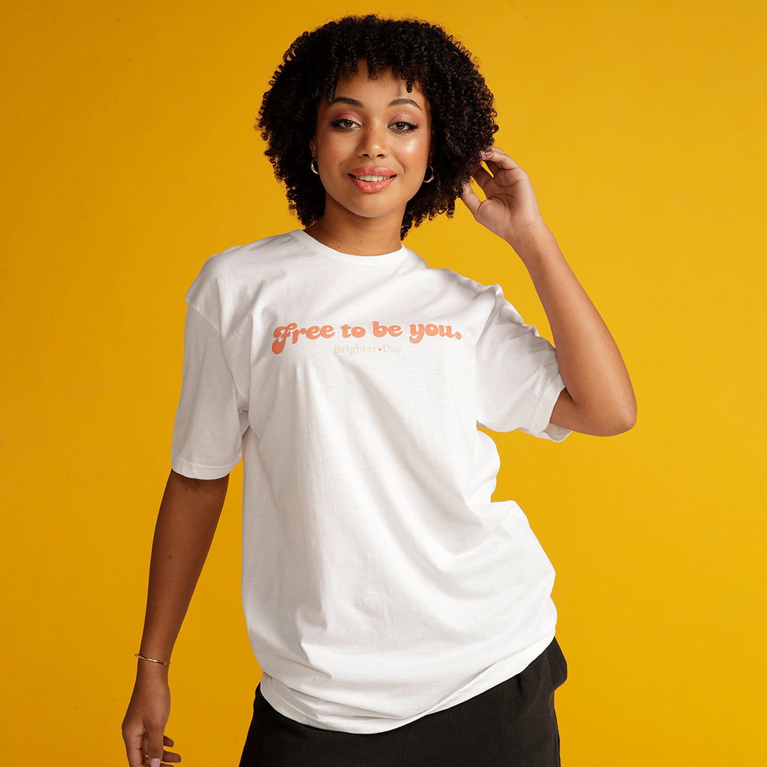 Curly Haired woman wears white Free to be you tee
