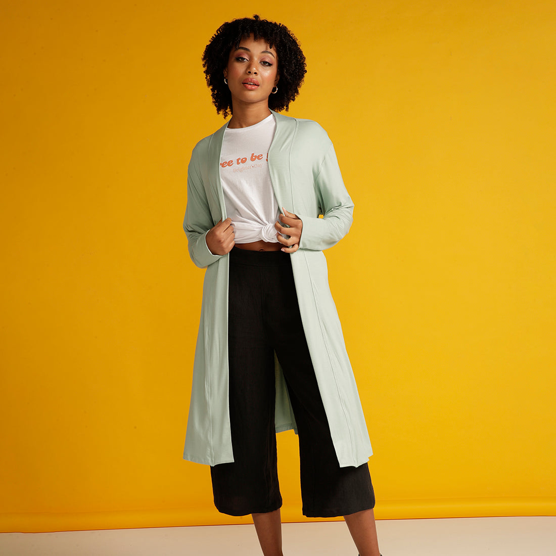 Curly haired woman in mint cardigan