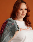 Woman wearing denim jacket with Nevertheless She Persisted enamel pin