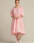 woman with red hair wearing a pink linen dress