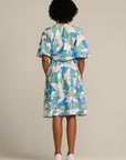 woman wearing a printed knee length ruffle dress facing the back
