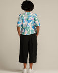 Back view curly haired woman in printed adaptive top