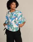Close up curly haired woman in printed adaptive clothes , top with ruffle detail