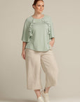 plus size woman in mint green top with port access detail