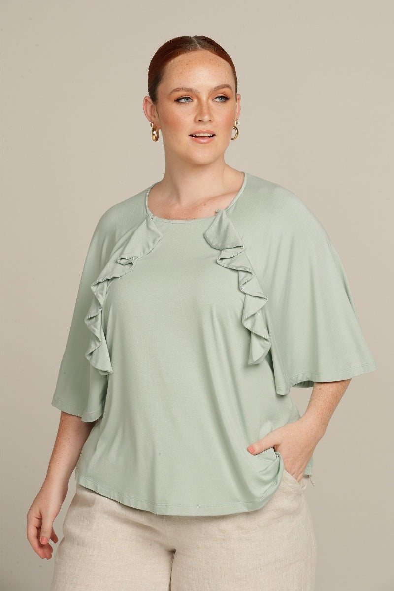 Close up plus size woman in mint green top with ruffle detail