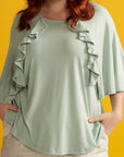 Close up plus sized woman in mint green adaptive top with ruffle detail