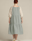 Back view plus sized woman wearing a sage green linen dress