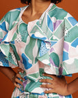 Close up Curly haired woman wears printed dress with ruffle detail