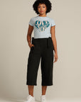 Curly haired woman wears black linen culottes
