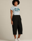 Curly haired woman wears black linen culottes