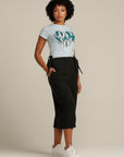 Curly haired woman wears black linen culottes with pockets