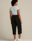 Back view of a curly haired woman wearing black linen culottes
