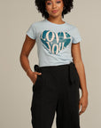 Close up of a curly haired woman wearing black linen culottes