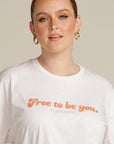 Close up of a red haired woman wearing a white Free To Be You tee