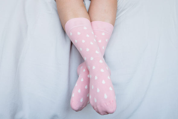 Close up of woman wearing pink socks with white spots