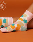 close up of socks with colourful splotches with an orange background