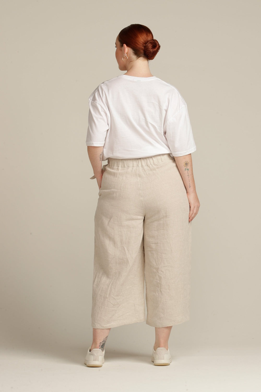 Back view of a plus sized woman wearing beige linen culottes