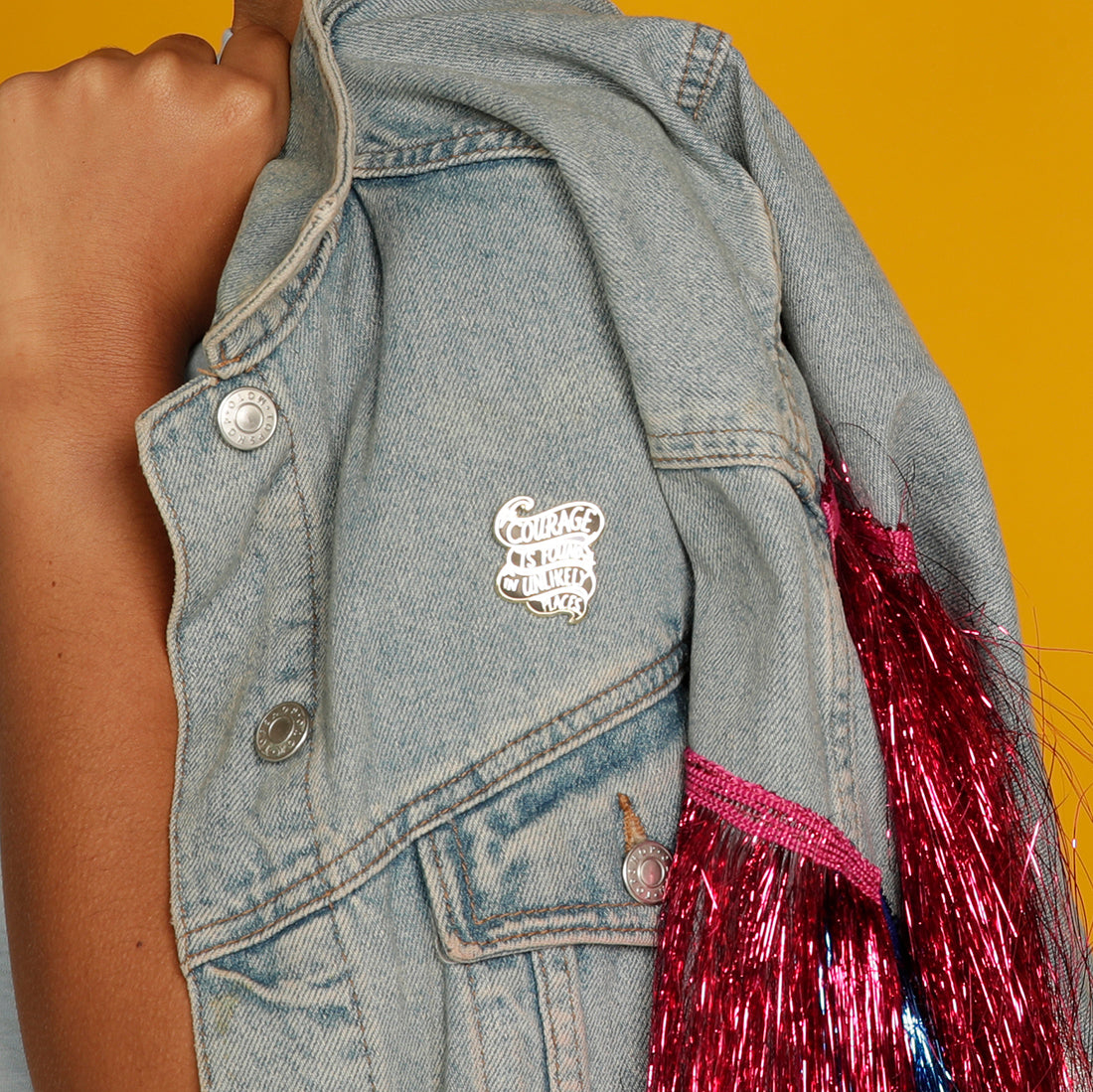 Courage is found in unlikely places enamel pin on a denim jacket
