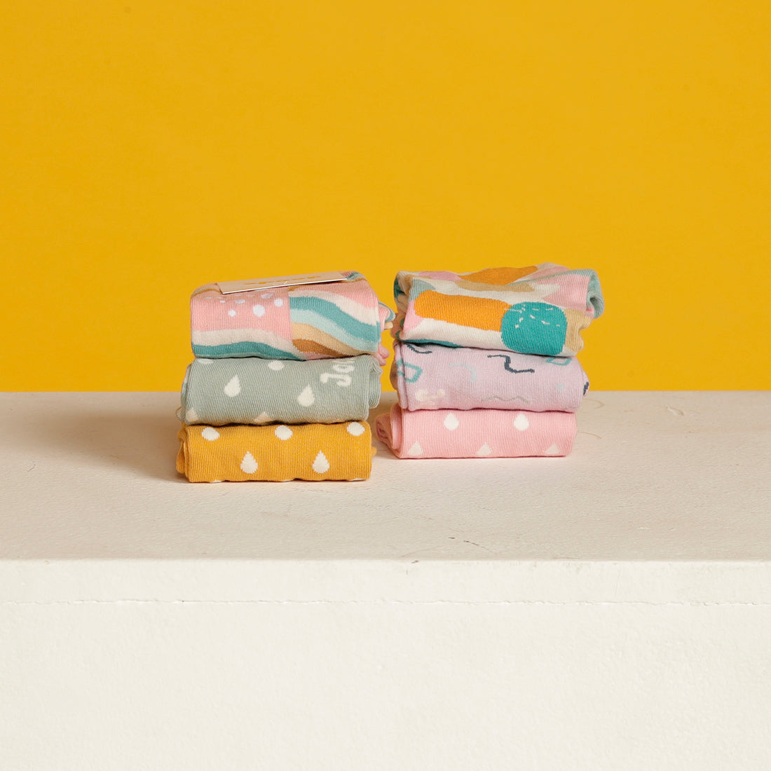 Six pairs of coloured socks folded in two piles