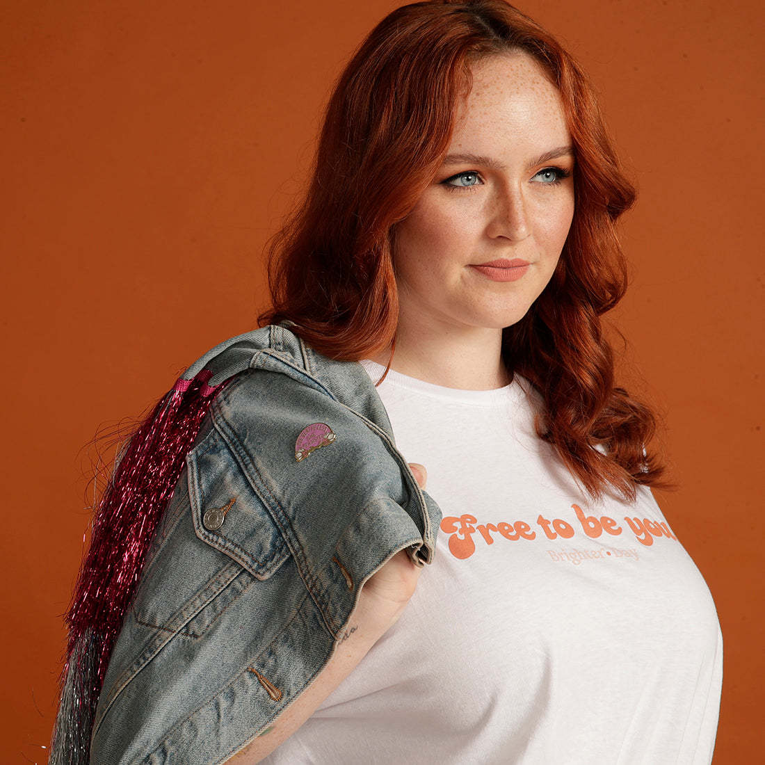 Woman wearing denim jacket with Nevertheless She Persisted enamel pin