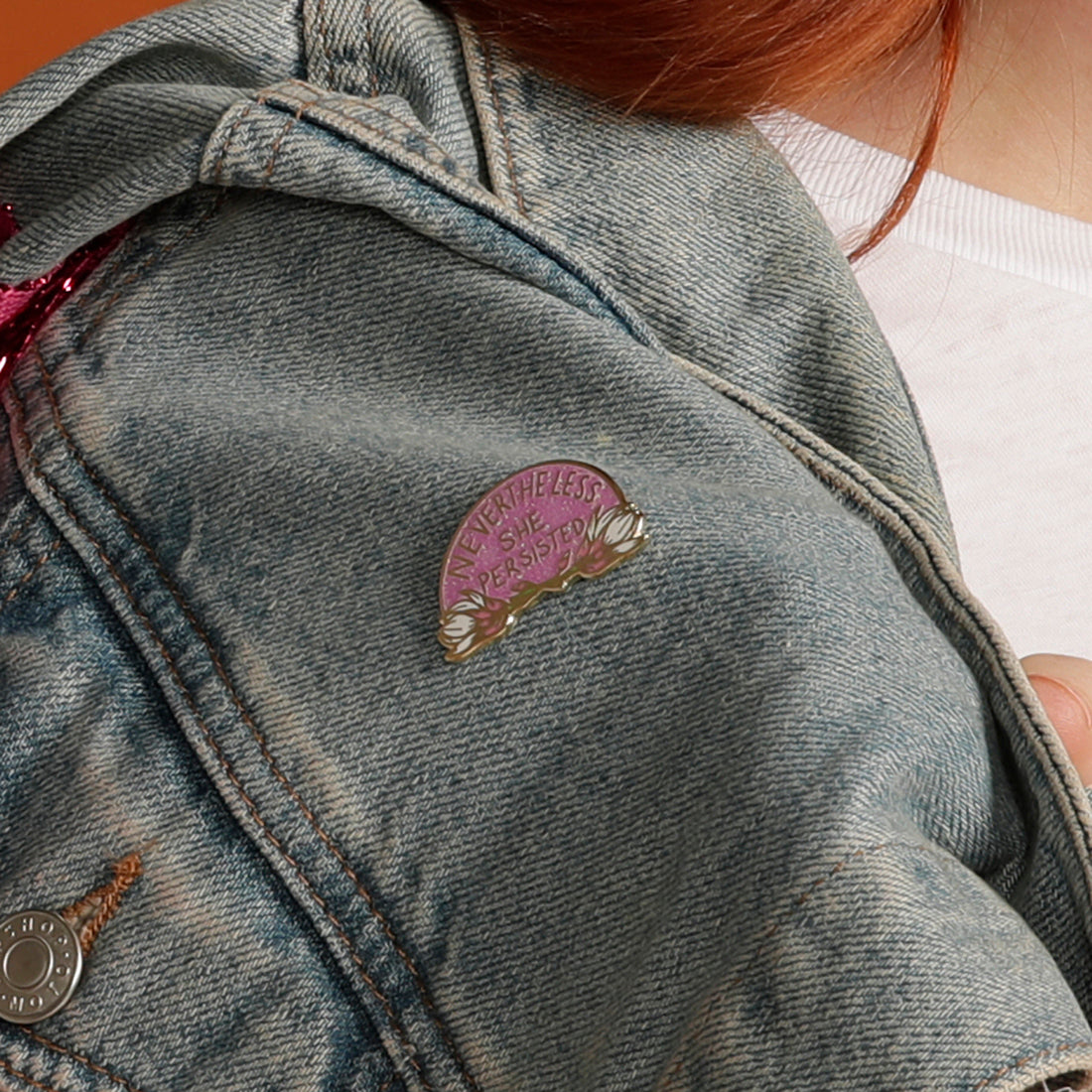 Nevertheless She Persisted enamel pin on denim jacket