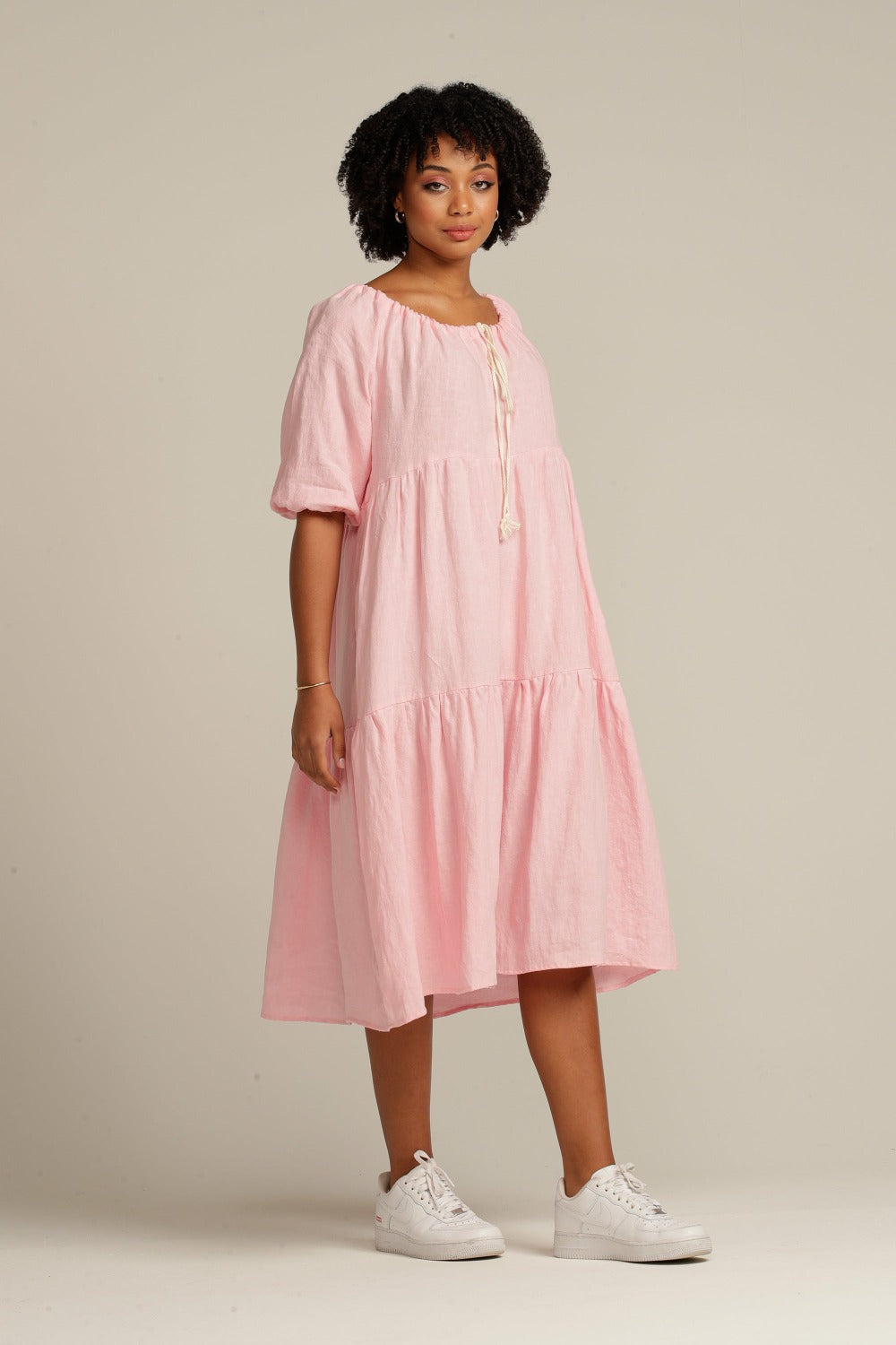 brown woman wearing a pink linen knee length dress