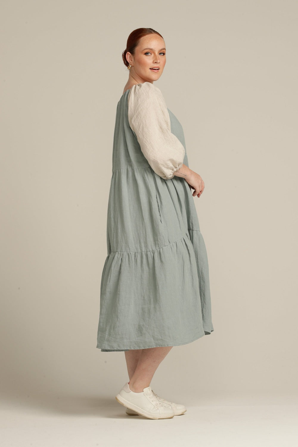 side view of sage linen dress, woman is looking at camera