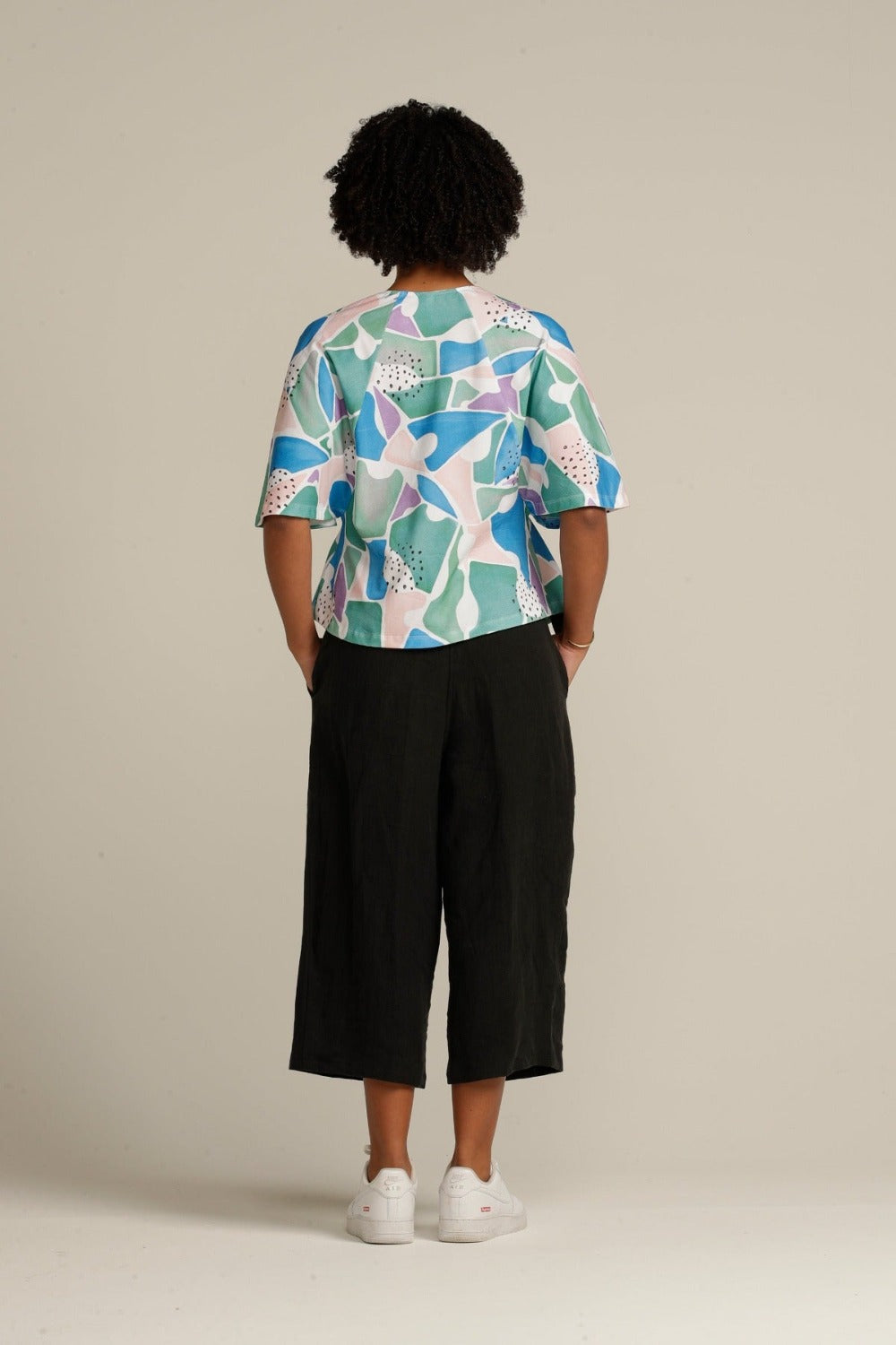 Back view curly haired woman in printed adaptive top 