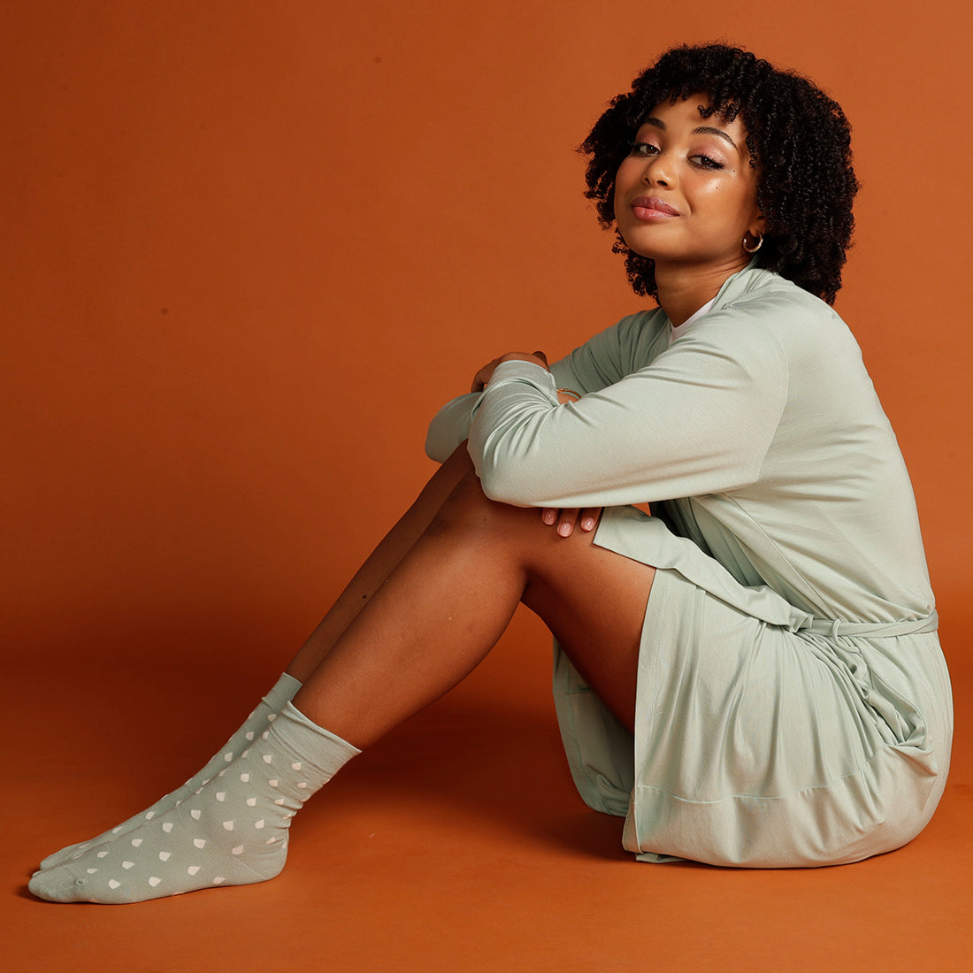 woman sitting down in mint cardigan with mint spotty socks