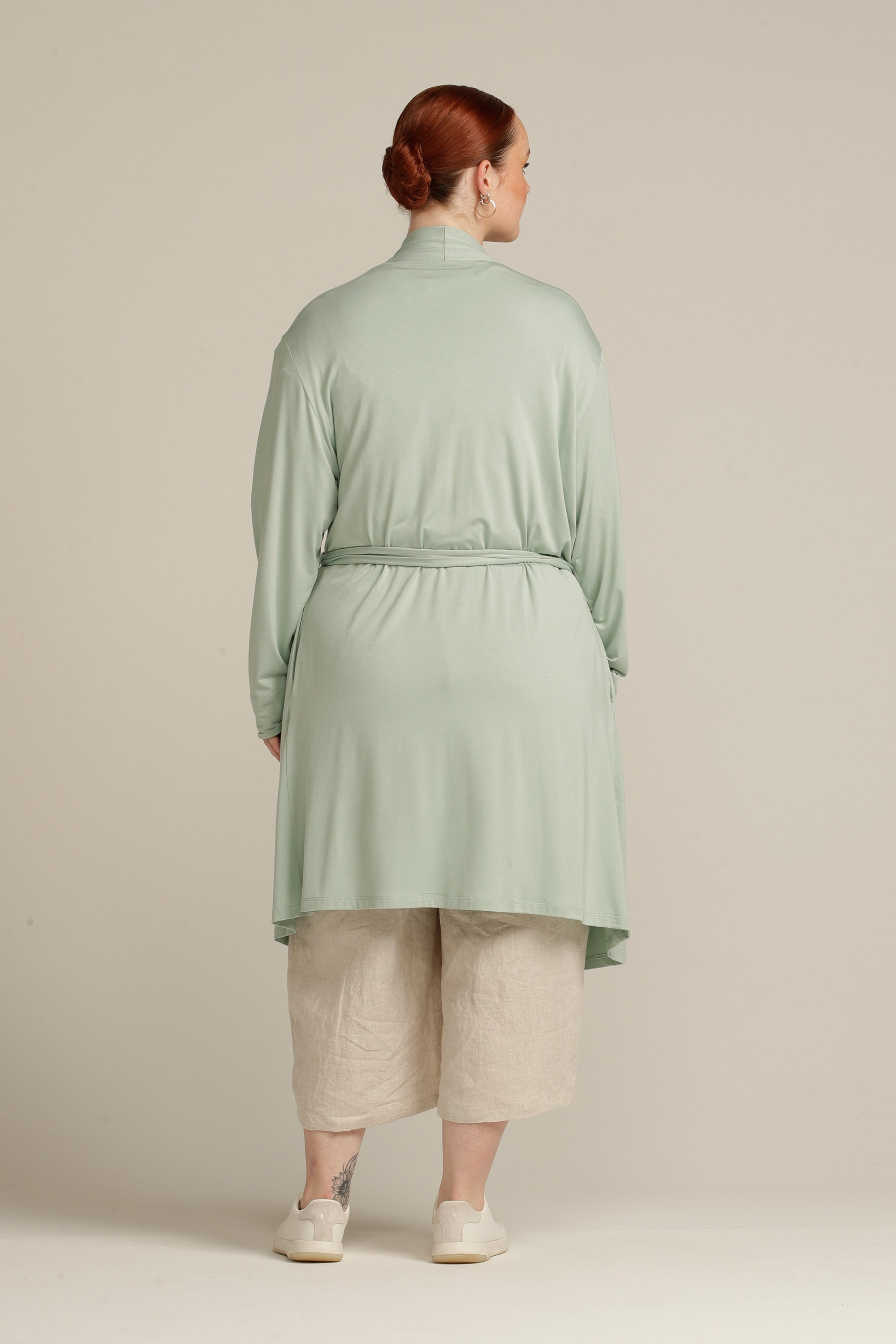 Back view plus size woman in mint cardigan