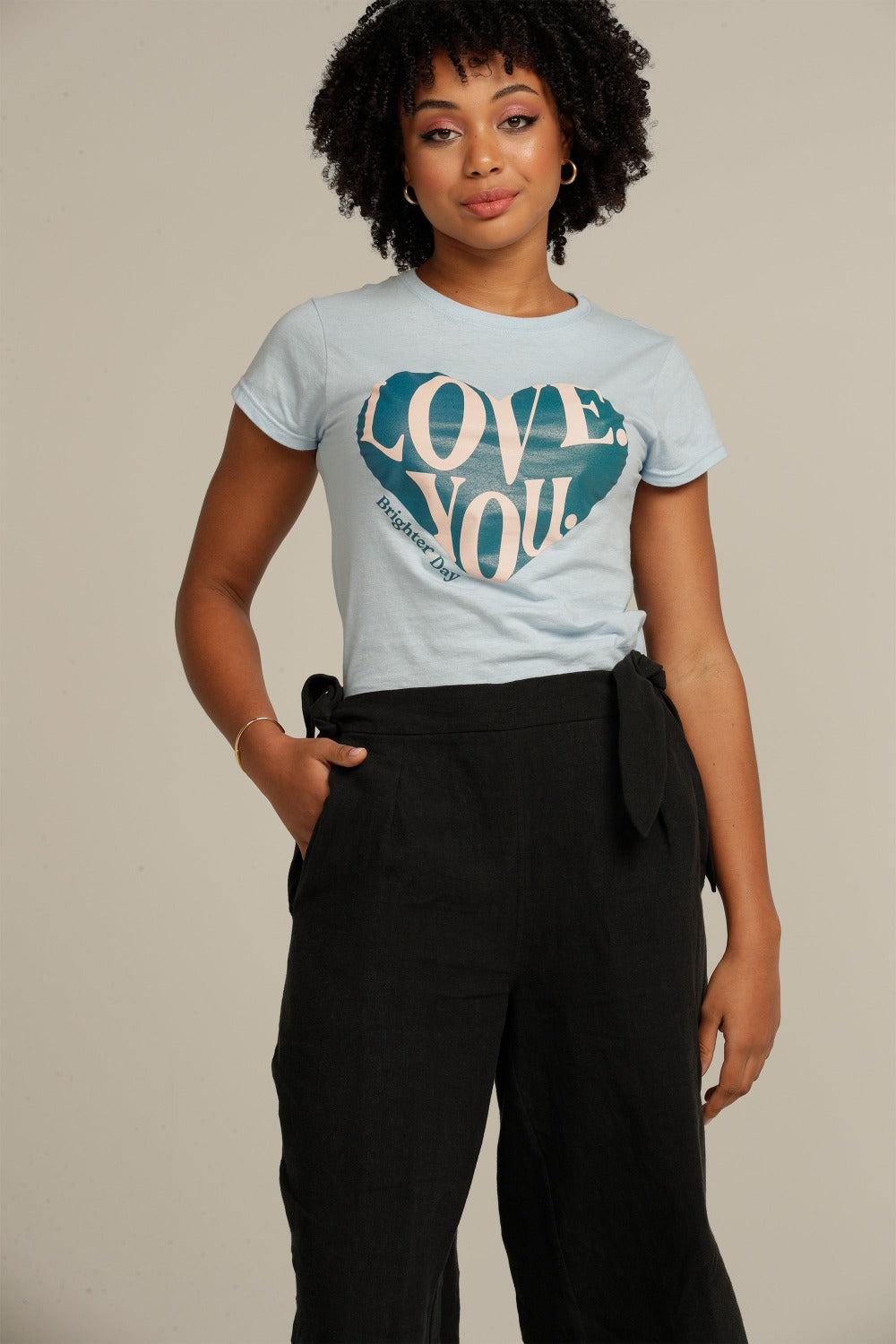 Close up of a curly haired woman wearing black linen culottes
