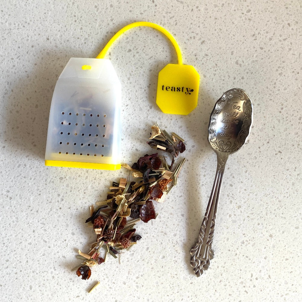 silicone tea diffuser with loose tea on a bench with a spoon