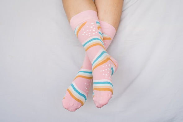 Close up of woman wearing pink socks with rainbows